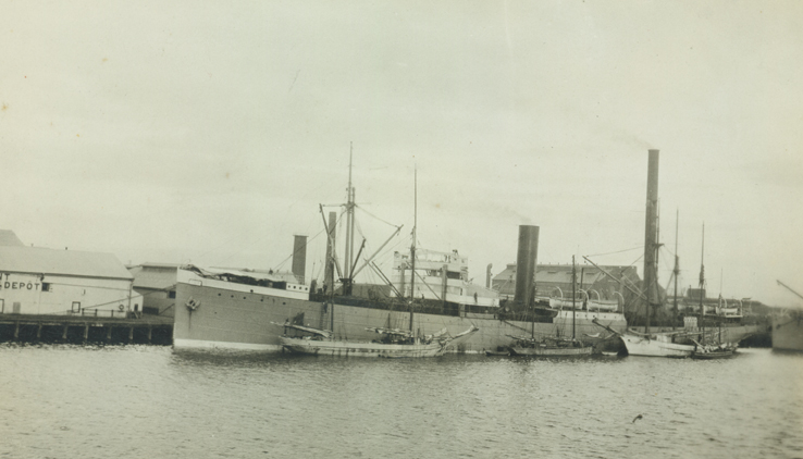 an old po of a large ship and a smaller boat in the water