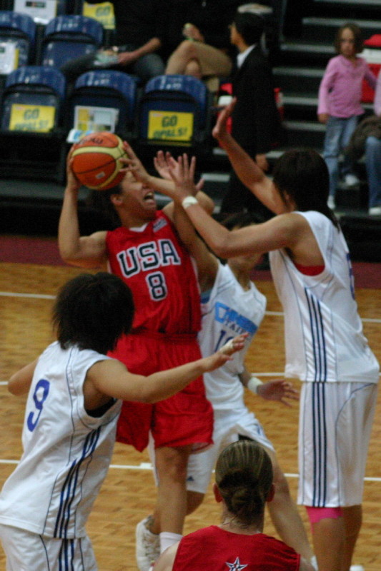 several girls in uniform trying to block the ball