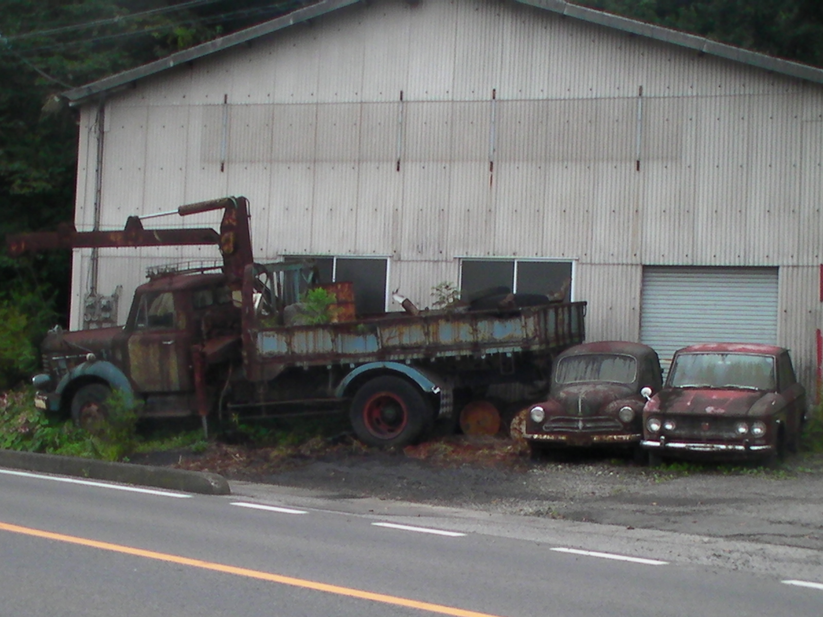 three old trucks sitting outside an abandoned building