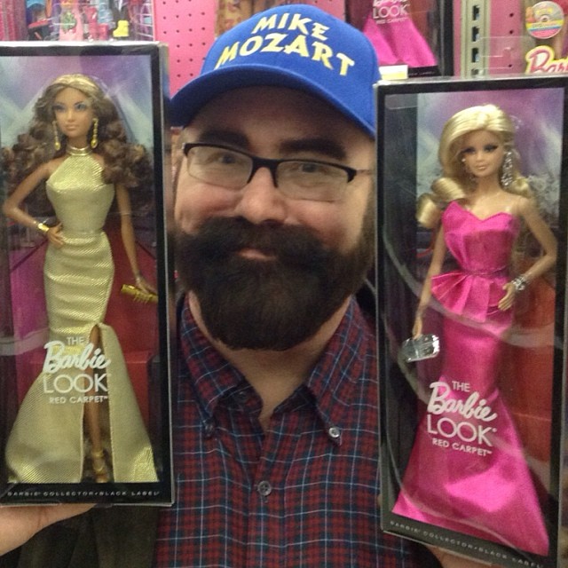 a man is shown holding two barbie dolls in his hands