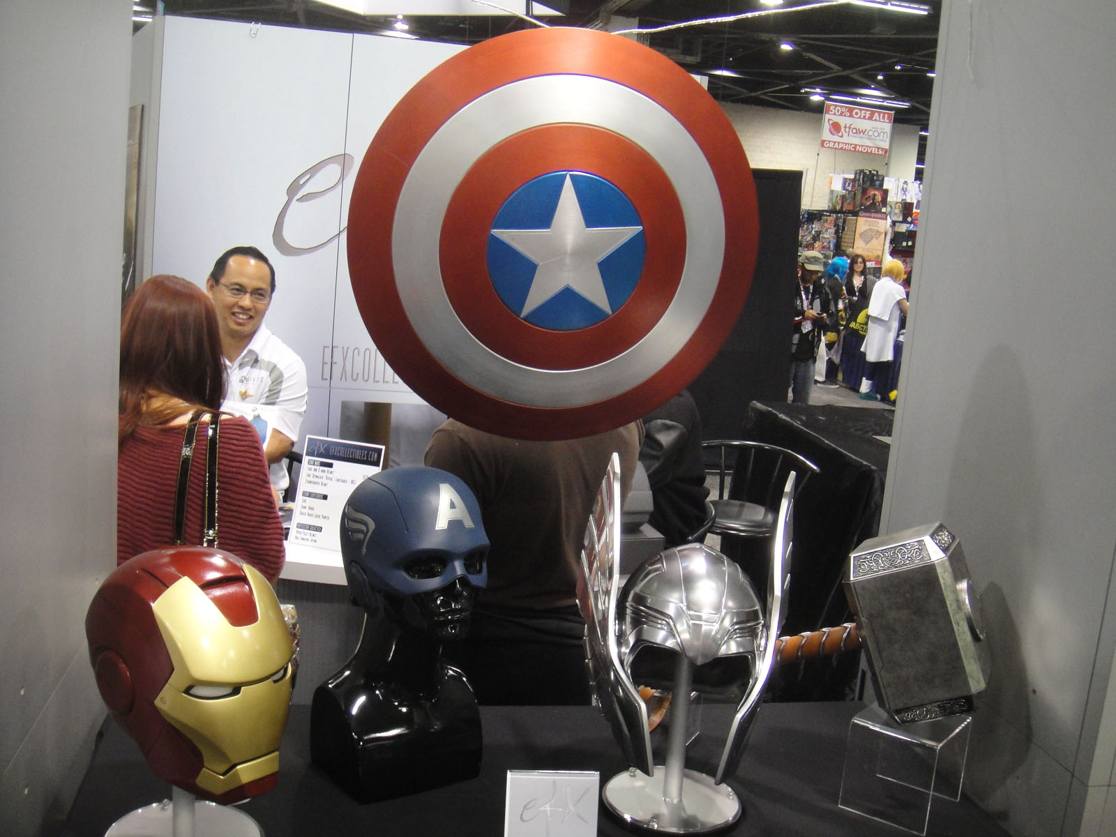 a person at a counter next to a statue of a captain america helmet