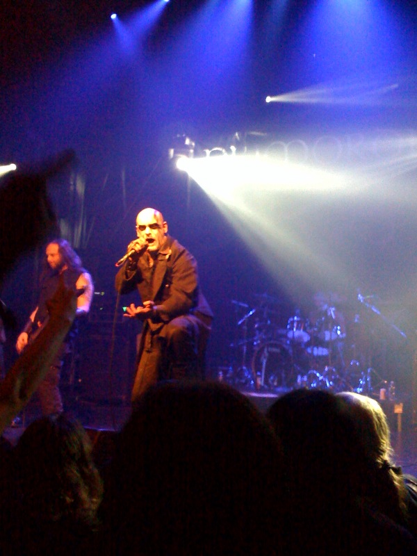 a man holding a microphone next to a crowd on stage