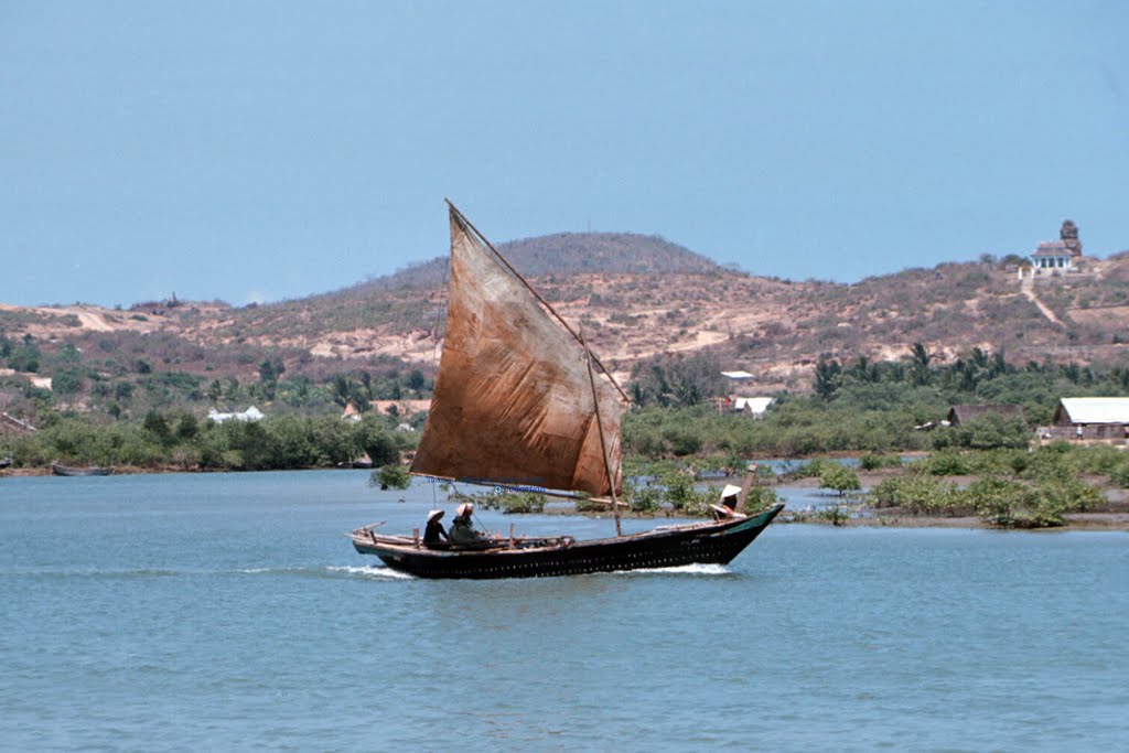 a boat is in the middle of a lake and on top of a hill