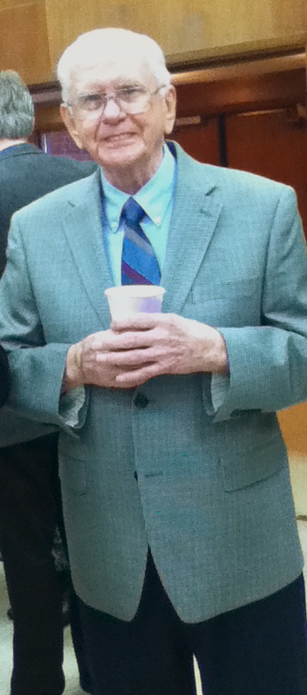 a man is holding a cup and standing next to other men