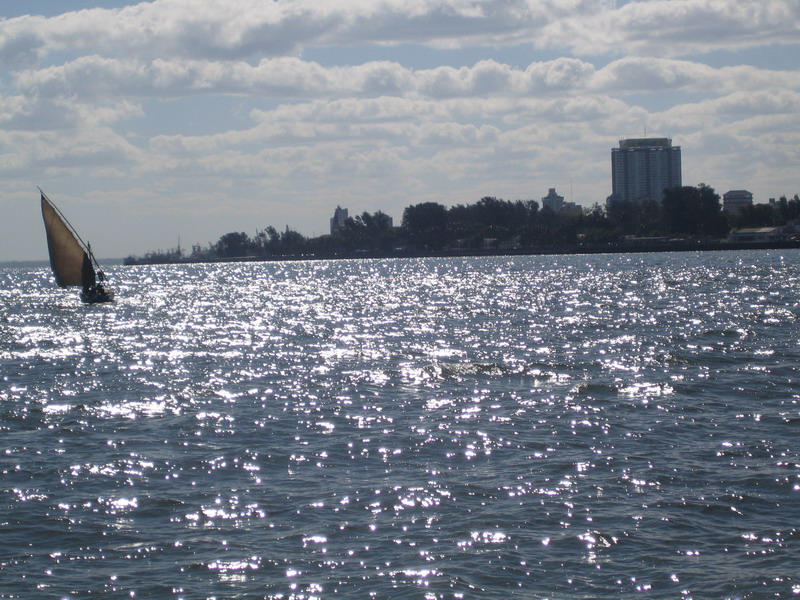 a small sail boat is seen from across the water