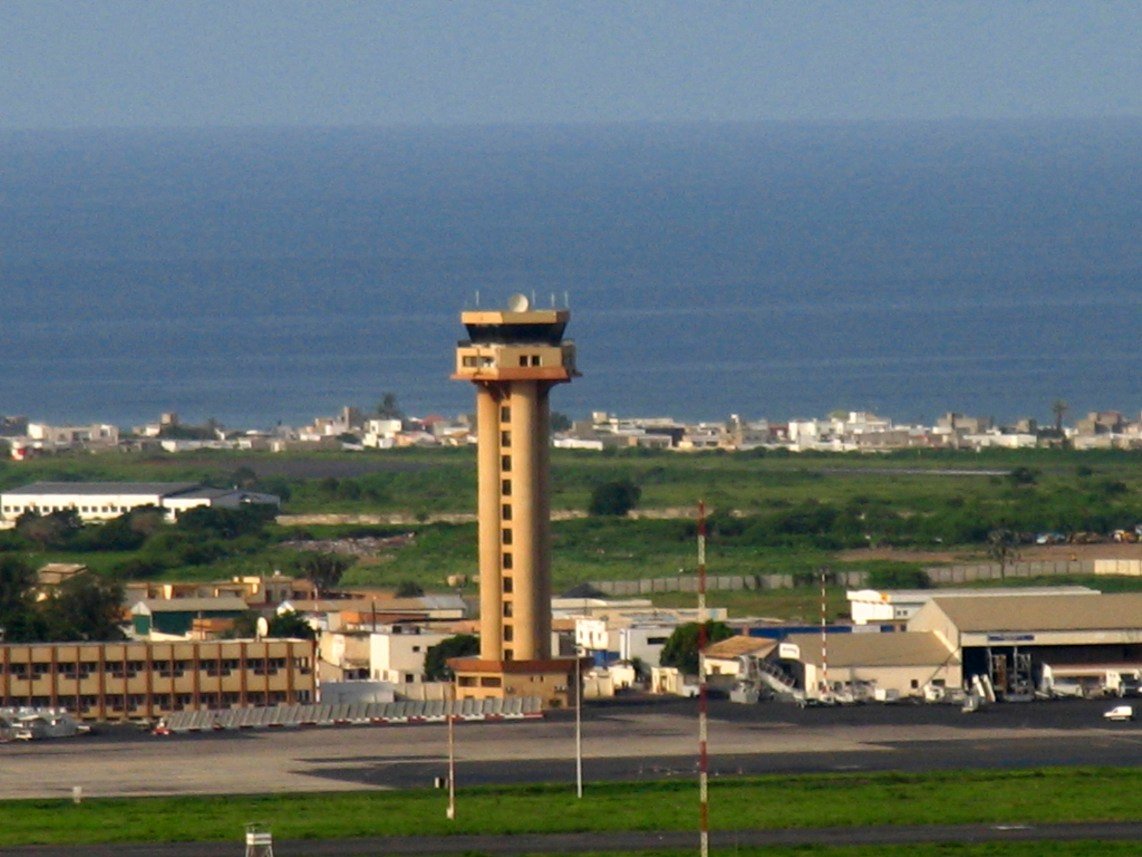an air port with a large building with a control tower in the center