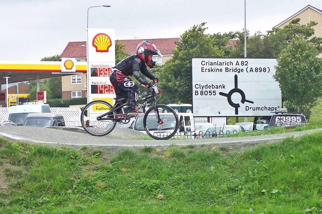 a bicycle rider rides his bike along the edge of a roundabout