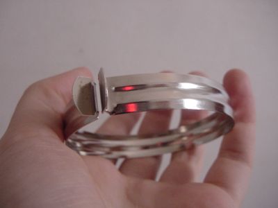 a person's hand holding a stack of thin silver rings