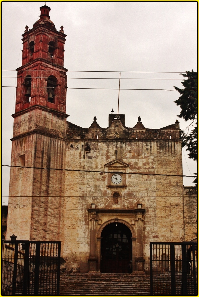 an old church with a clock tower behind the gates