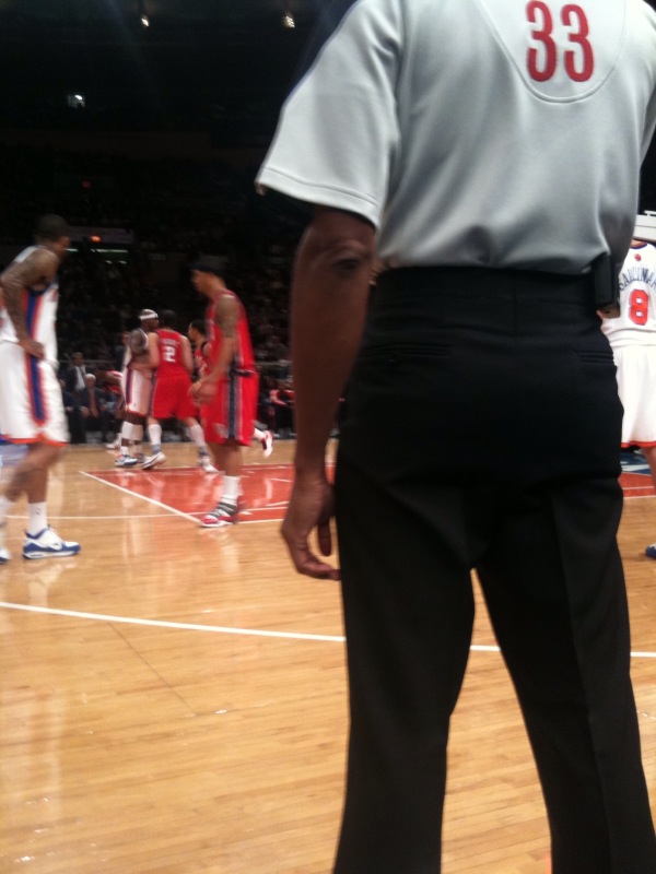 referee watching ball game on hard wood court