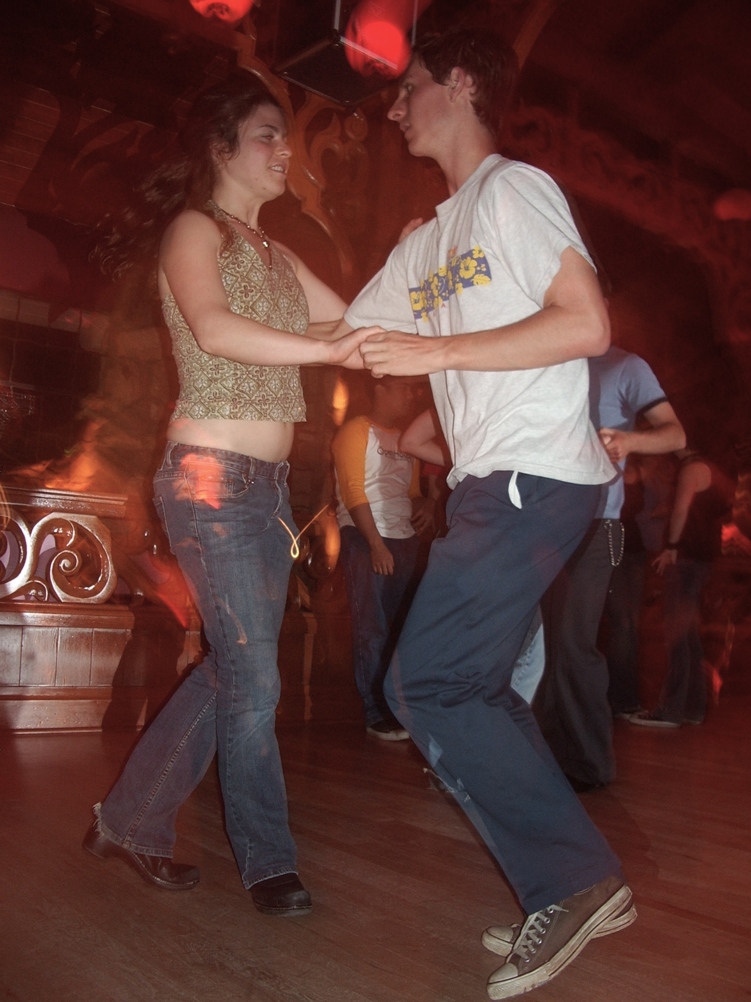 a couple dancing a latin dance with others behind