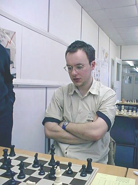 a man playing chess with other men