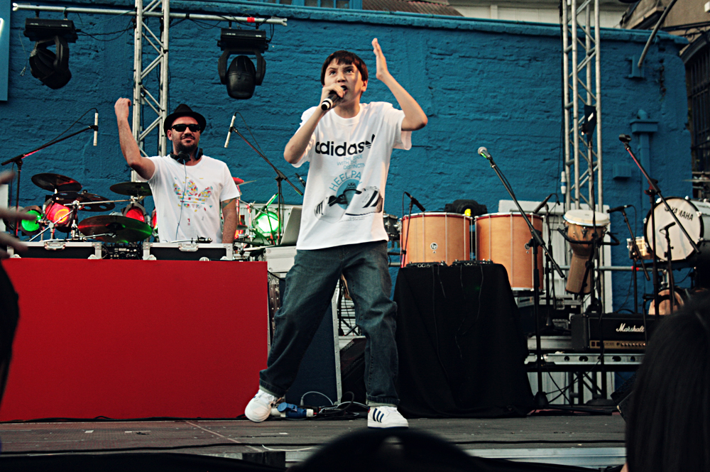 two young men standing on stage while holding up their hands