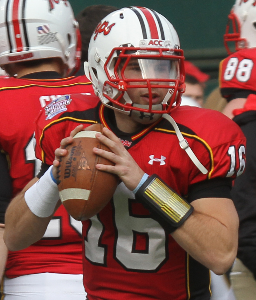 a football player holding a ball on a field