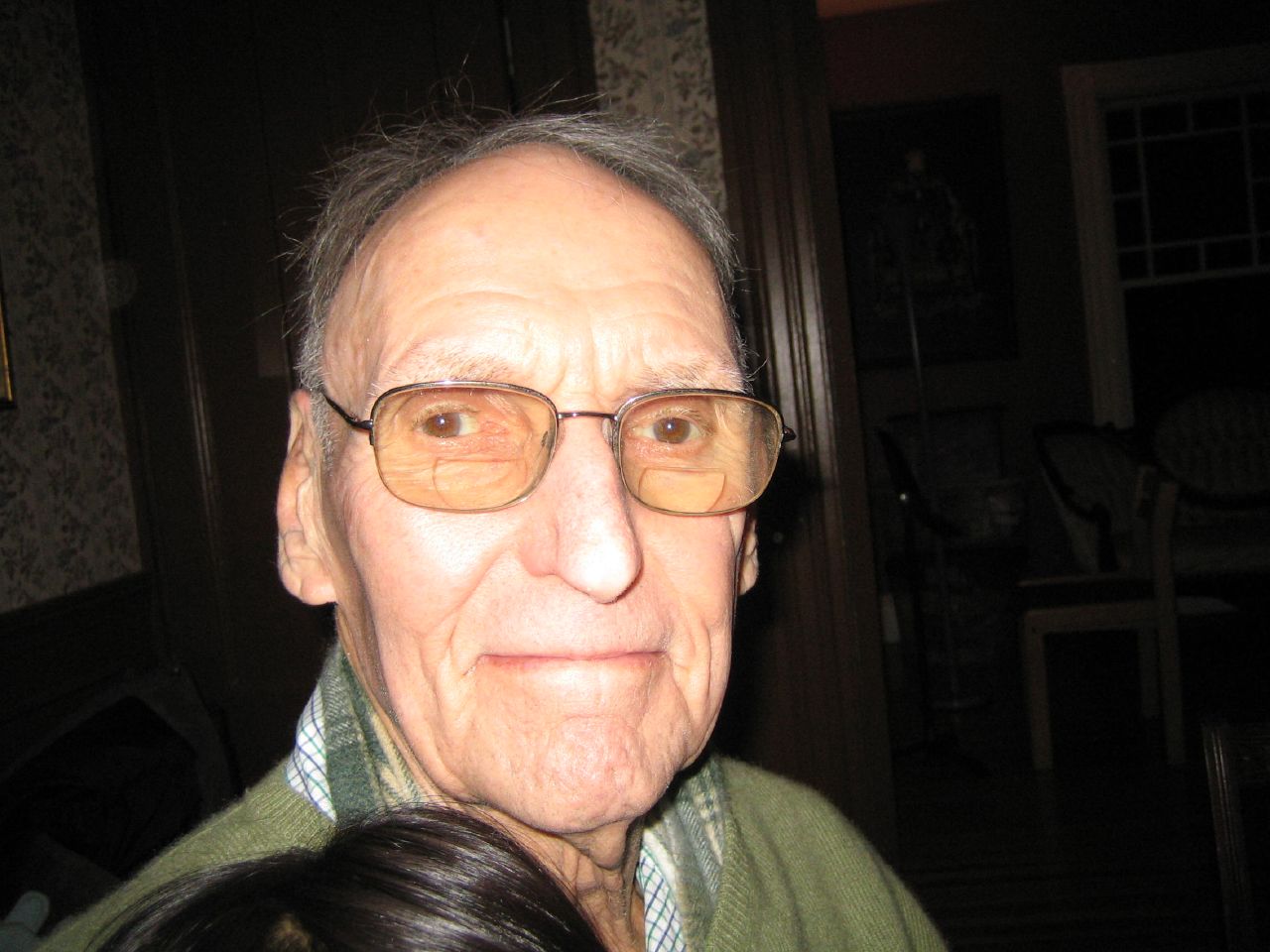an older man wearing glasses is smiling at the camera
