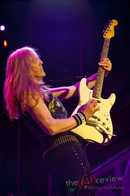 a person with long hair playing a guitar