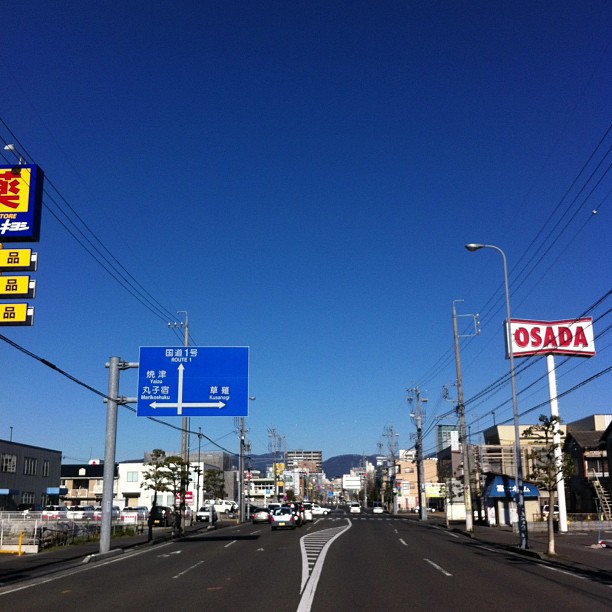 a street with lots of street signs and wires overhead