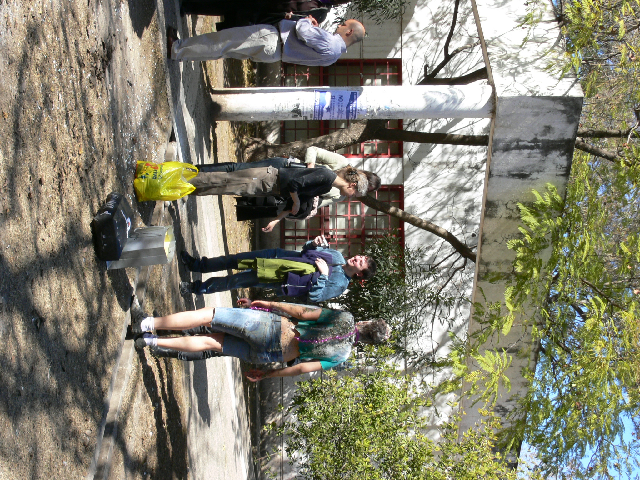 several people on the side walk walking up the street