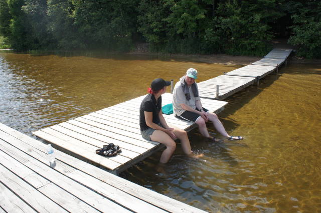 people sitting on the dock while using their phones