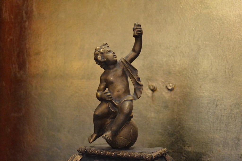 a statue of a child reaching for soing