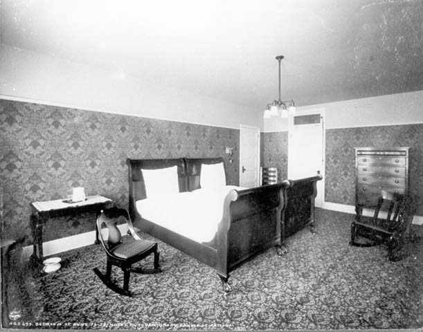 black and white pograph of a bedroom with high ceilings