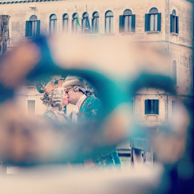 a couple kissing in front of a window