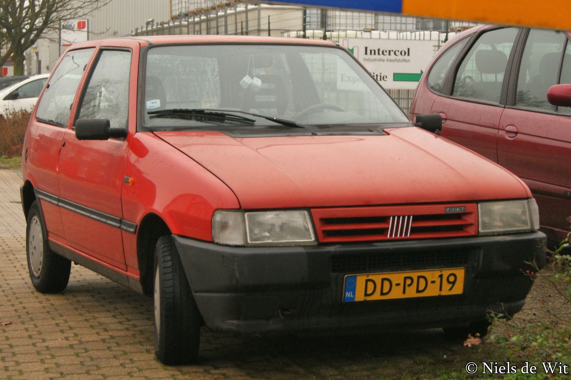 an old red van is parked on a brick road