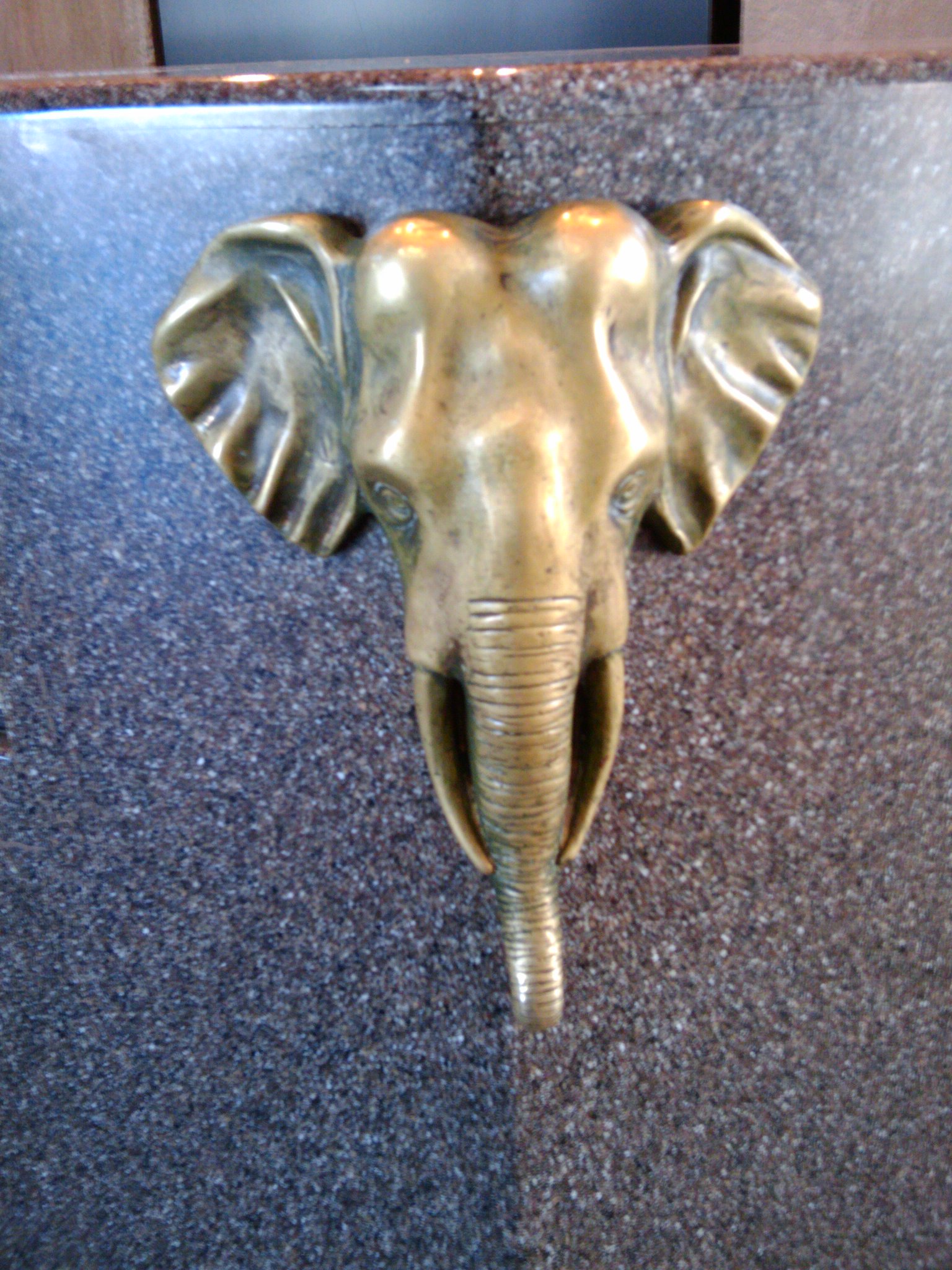 a close up of a gold metal elephant head