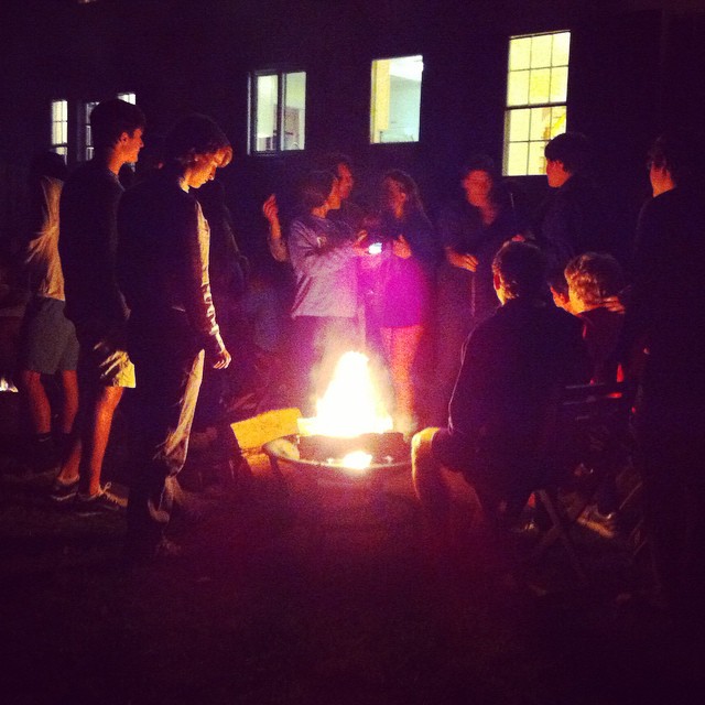 a group of people standing around a fire pit