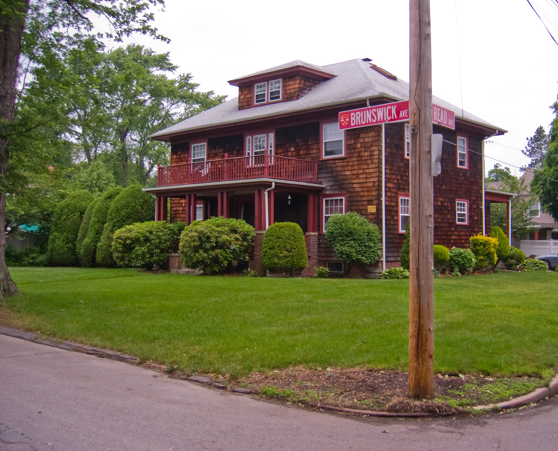 a two story house with bushes on the front and back