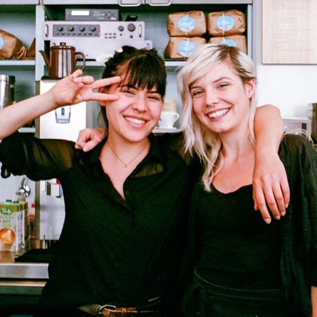 two young women are posing in front of a counter