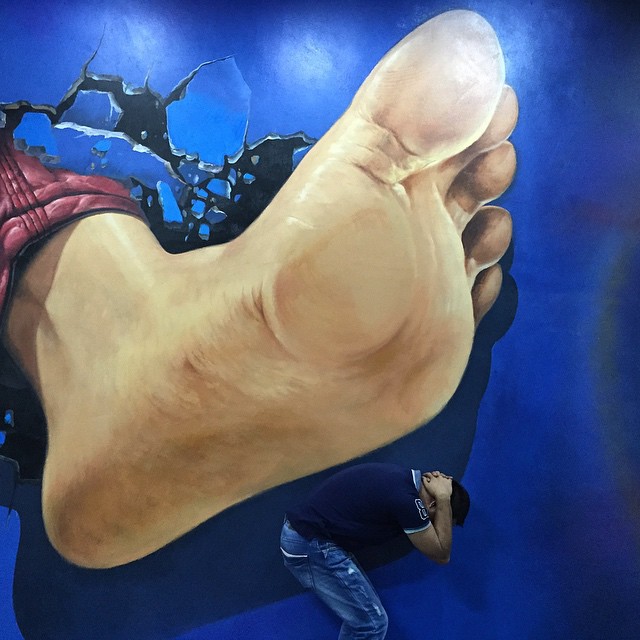 a person looking at the feet of a large painting