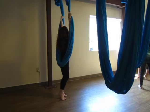 two people doing aerial yoga exercises on ropes