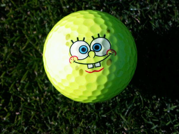 a green golf ball with a yellow face on the top