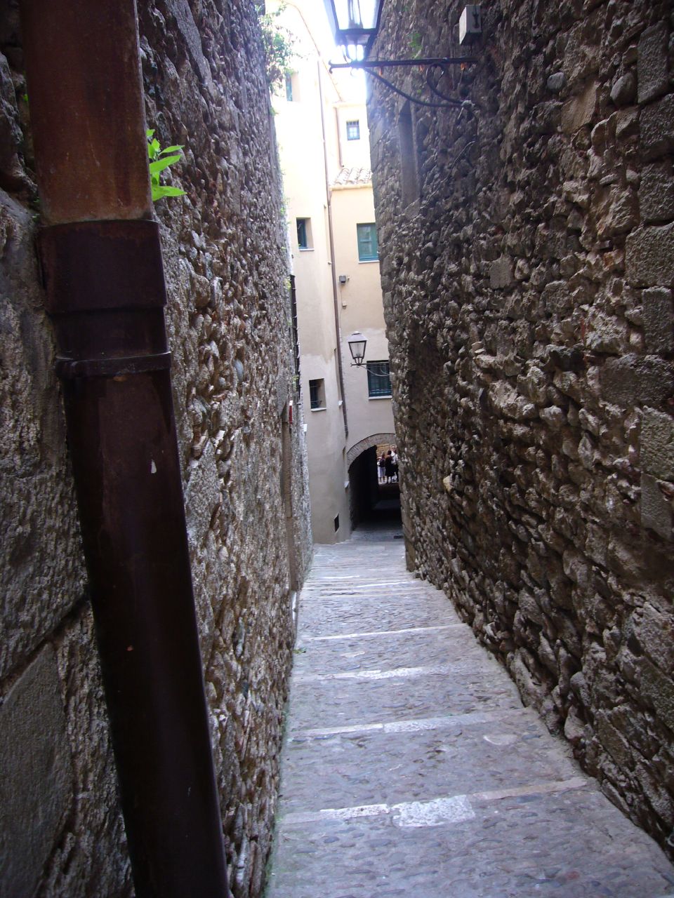 an alleyway with stairs going through it and some buildings in the background