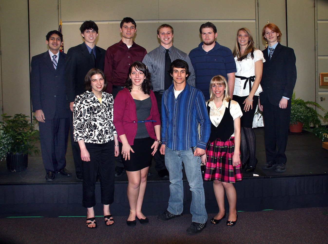 a group of people standing on a stage next to each other