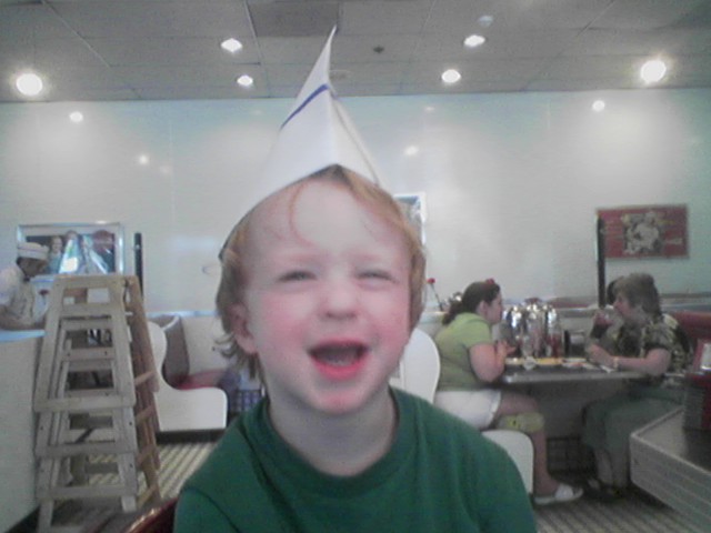 a  wearing a birthday hat, laughing