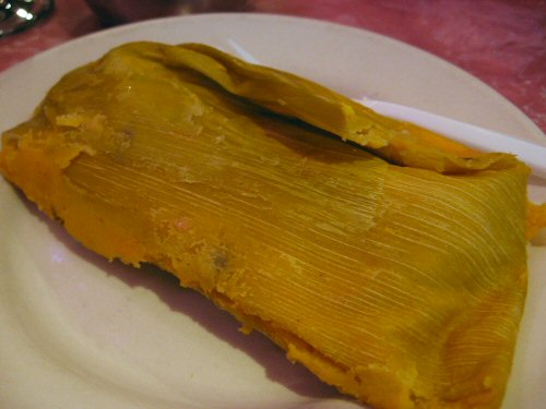 a large tamales sits on a white plate