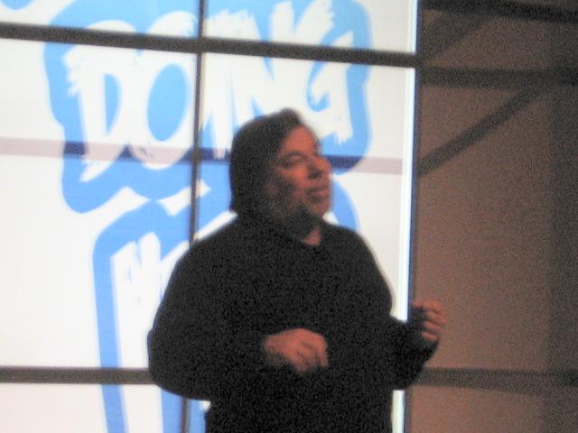 a man standing in front of a projection screen talking