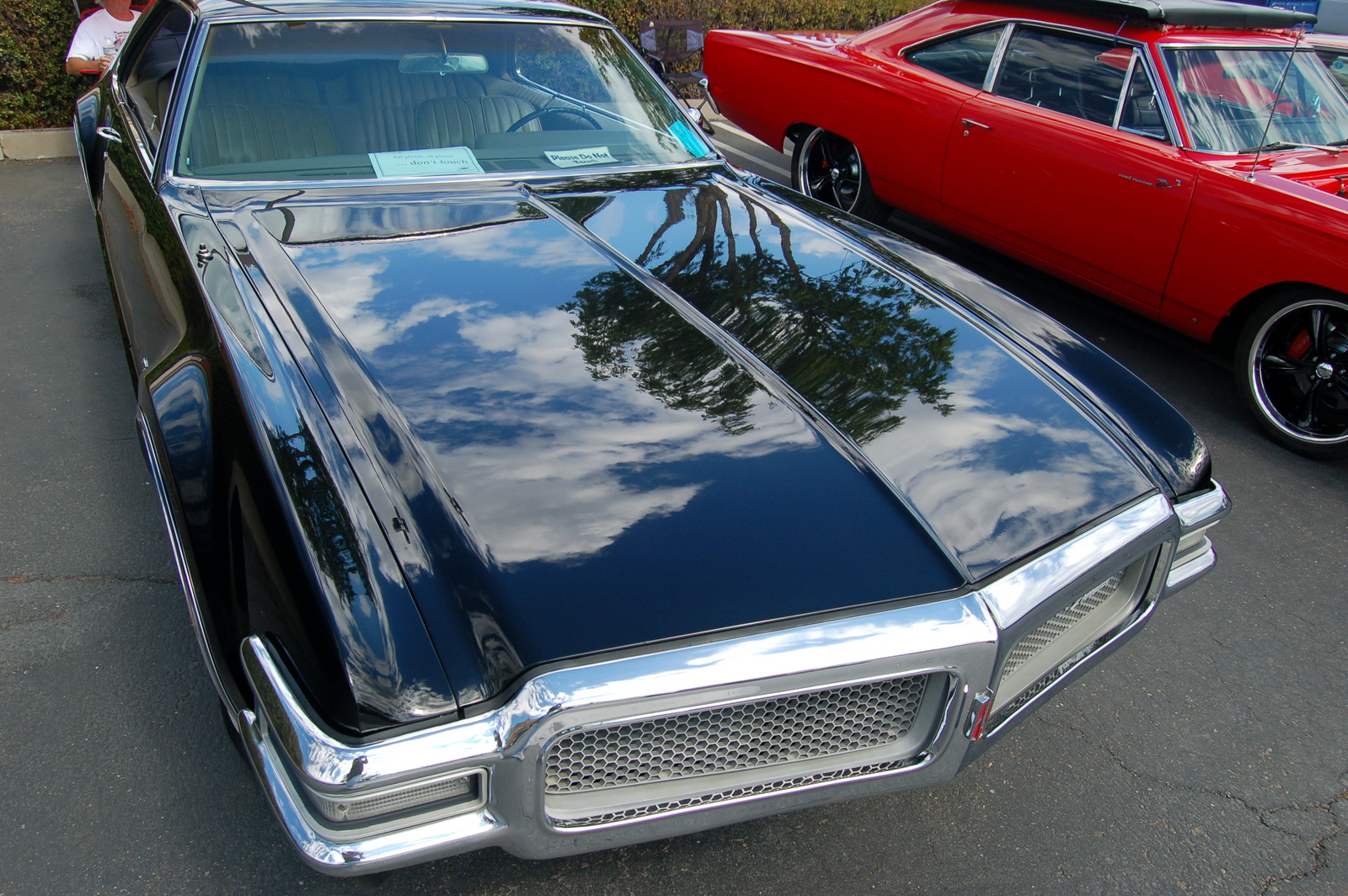 a nice, clean car parked in front of a classic red car