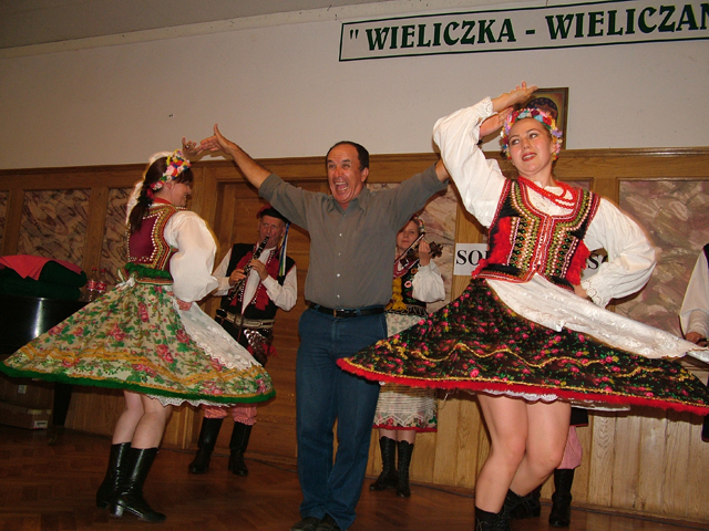 two people dancing on stage with their arms in the air