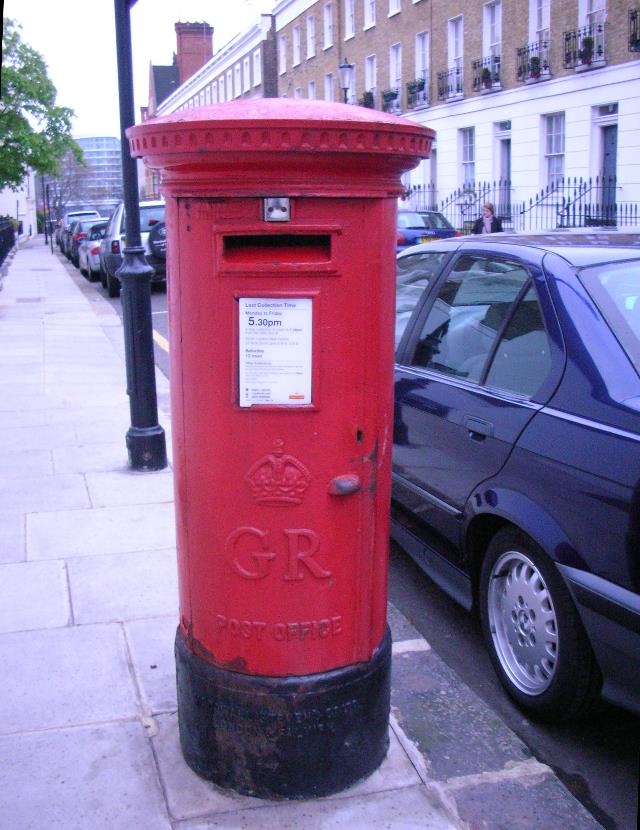 a red mailbox sitting next to a street
