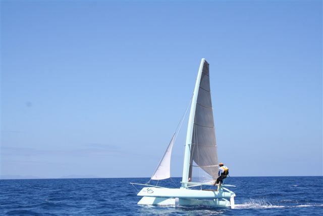 a sail boat in the open ocean near land