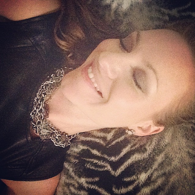 woman smiling at viewer while laying down in animal print outfit