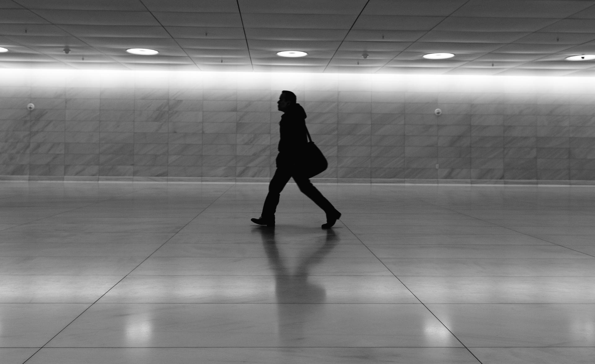 a woman with a suitcase walks in a tunnel