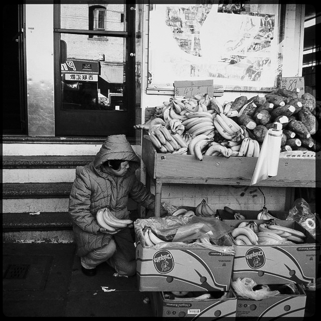 the woman is sitting next to a lot of bananas