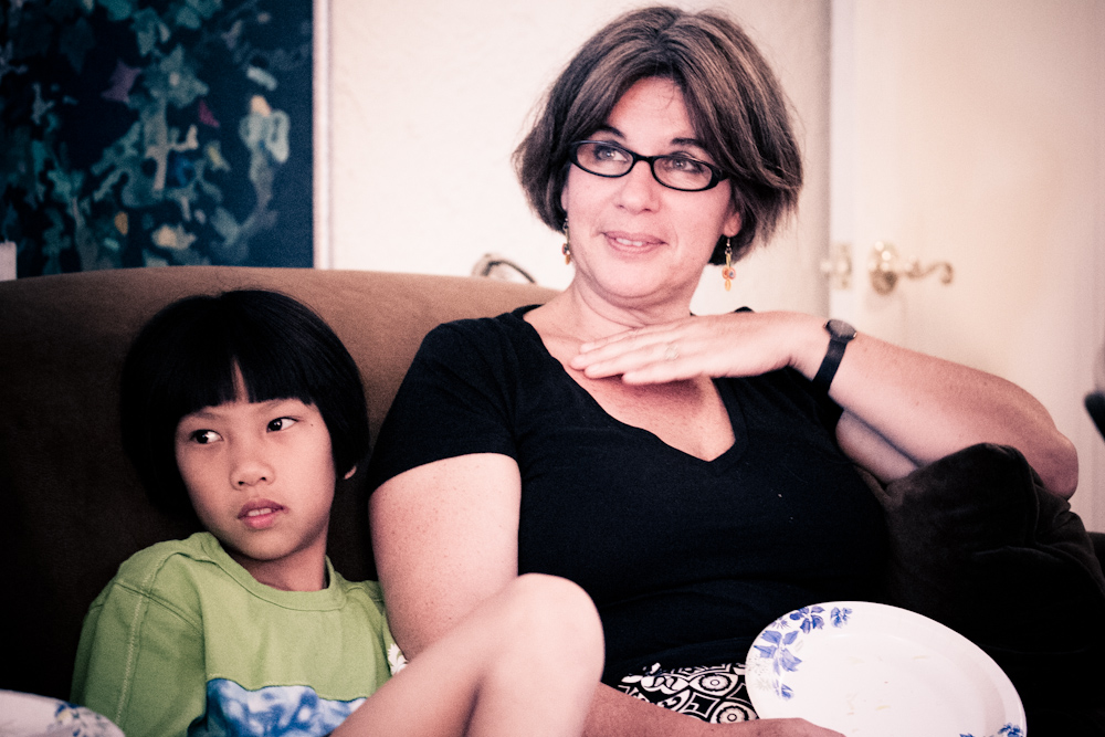 an adult sitting on the couch with a child