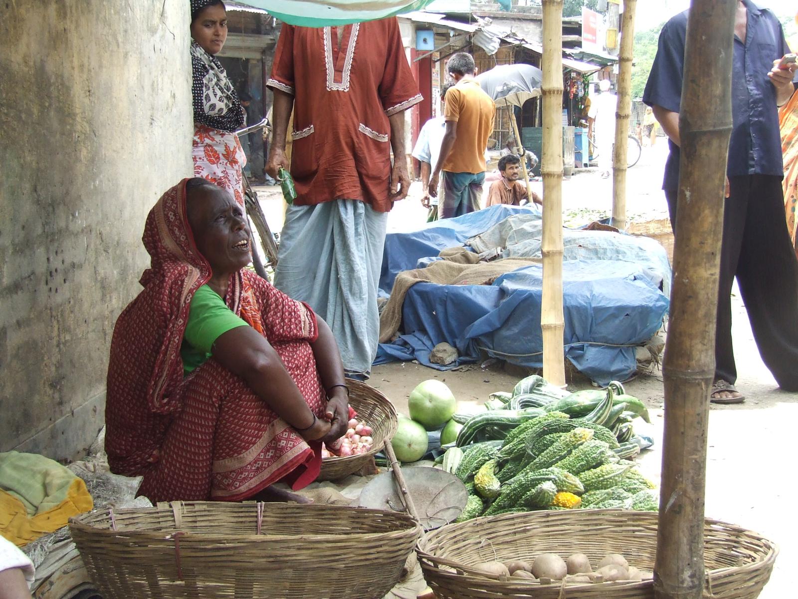 several people in a market place with baskets full of vegetables