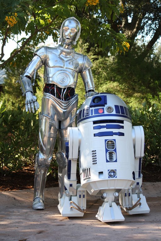 the star wars robot is standing in front of a giant toy r2d2