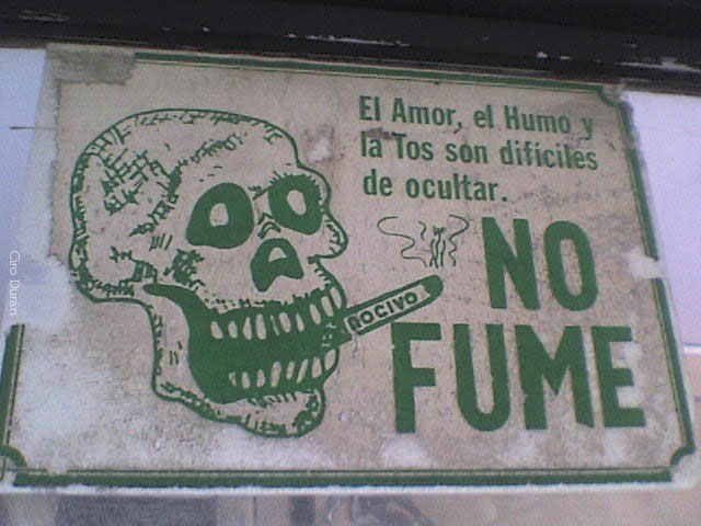 the sign says no fume in spanish, a skull and a cigarette